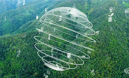 緑に覆われた山を背景に地球をイメージした球体が浮かぶ様子